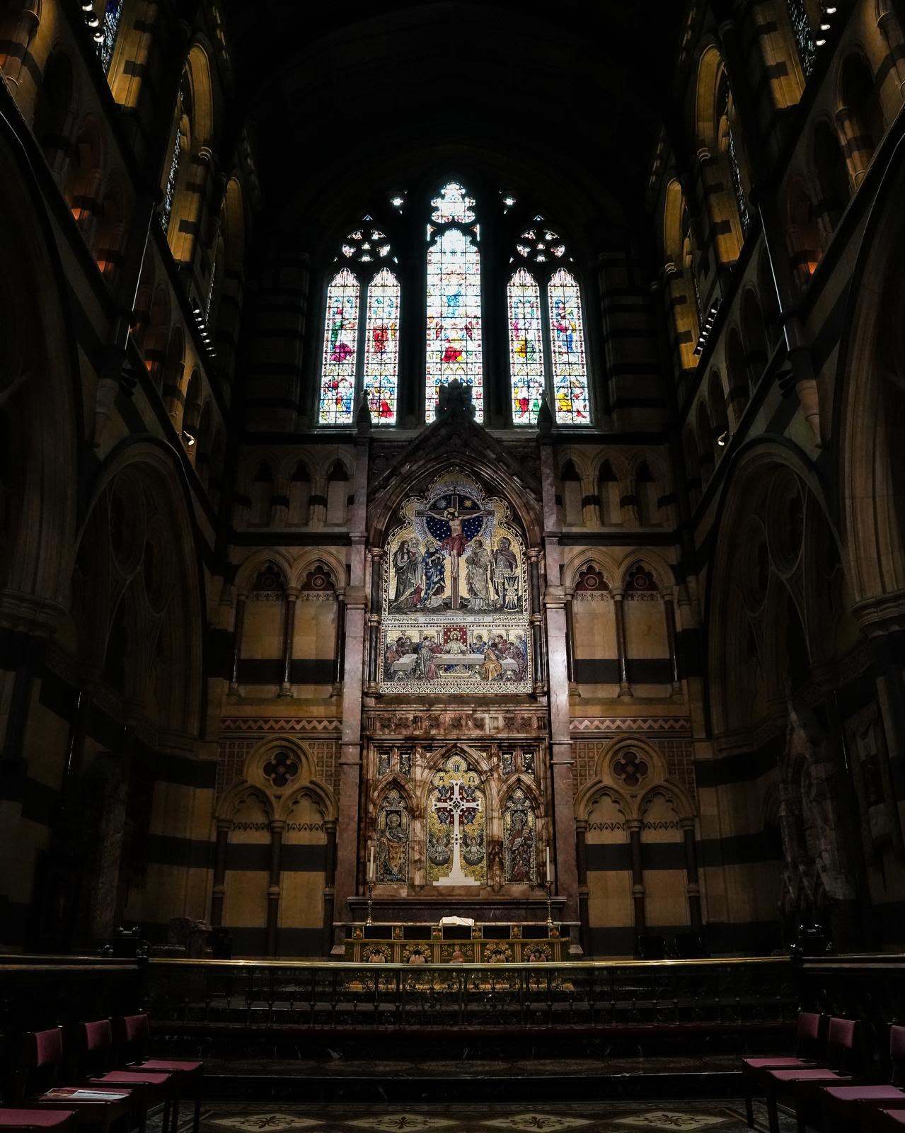 Interior of St Paul's Cathedral in Melbourne with stained glass above the altar