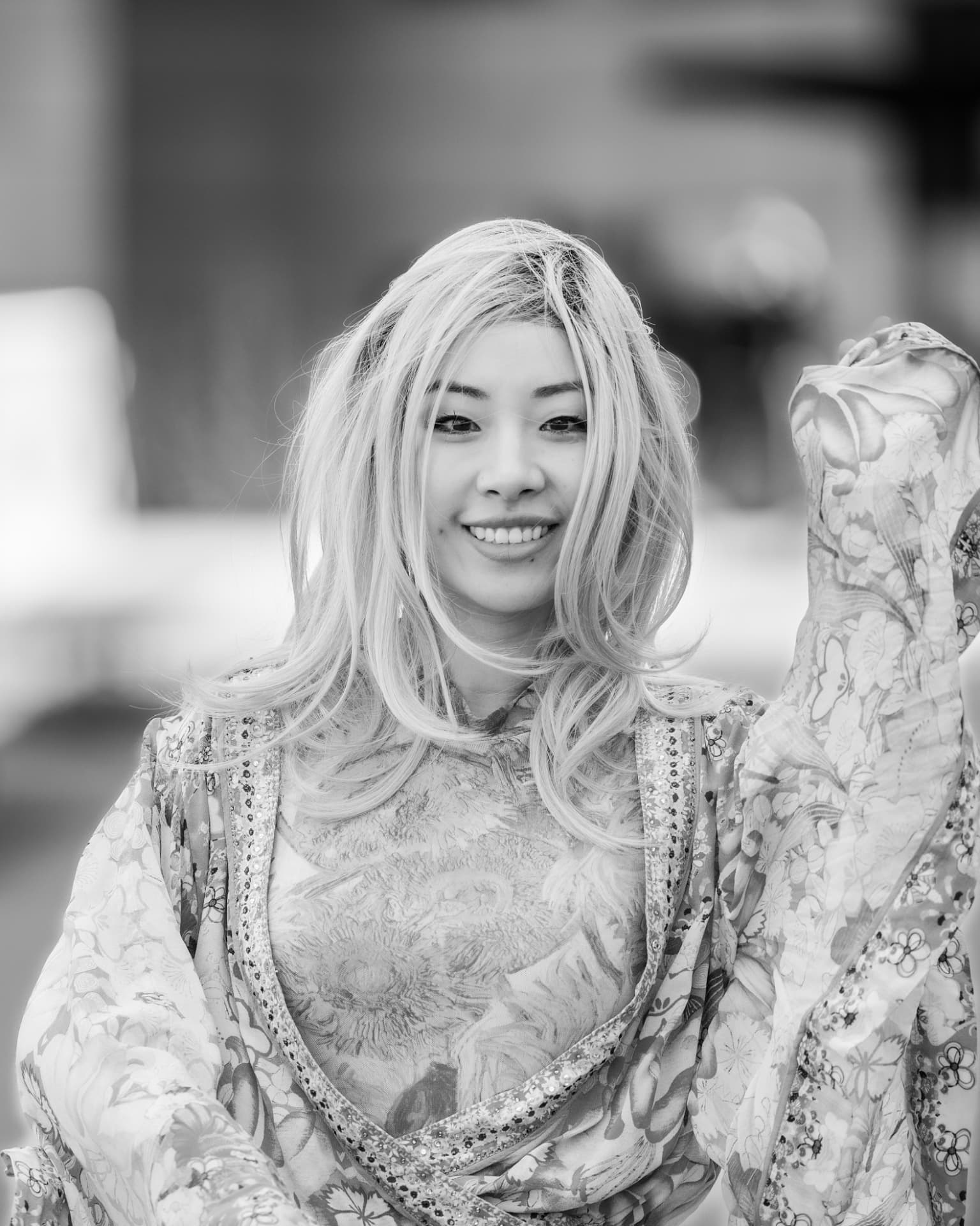 Black and white portrait of a smiling woman in a patterned floral outfit