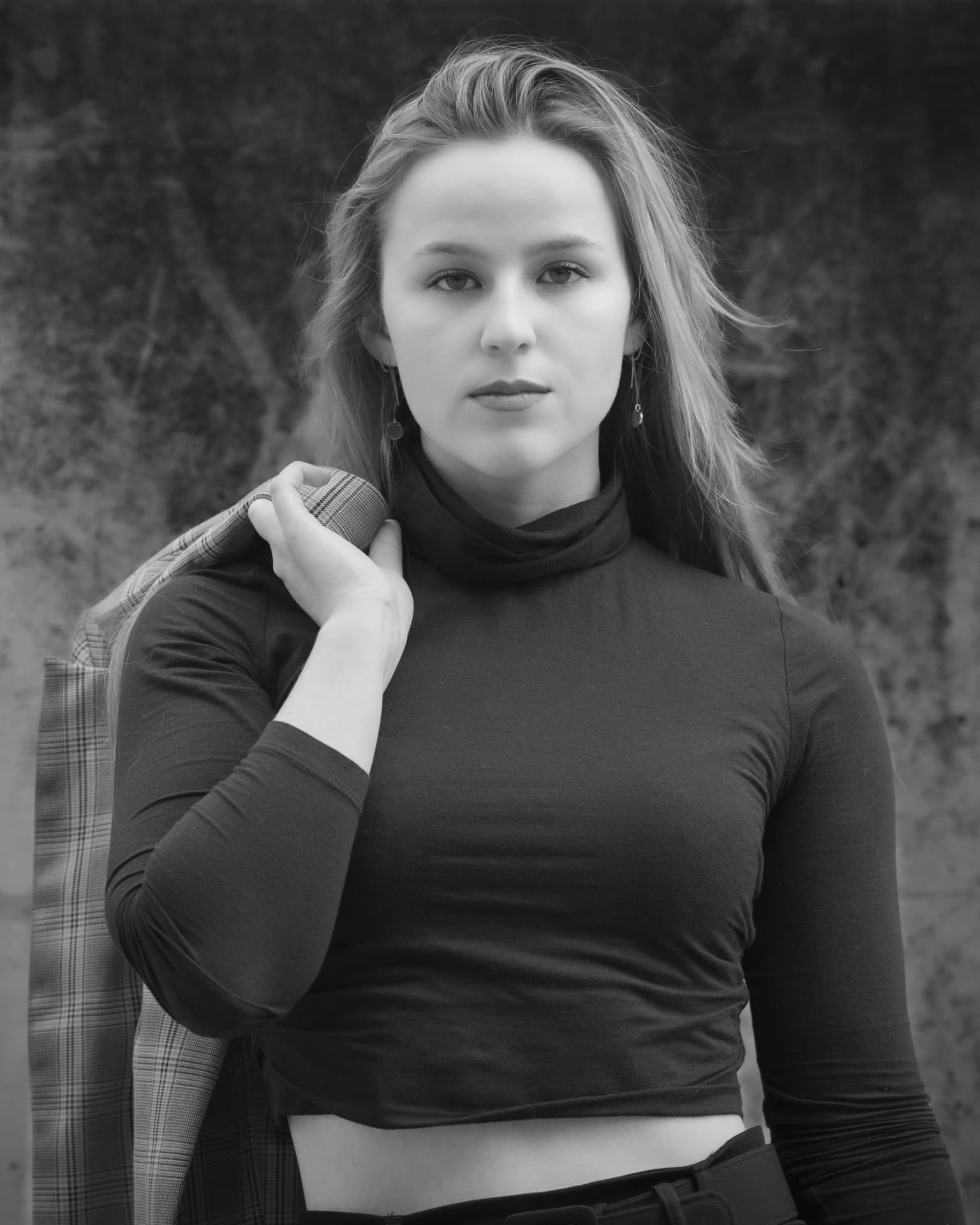 Black and white portrait of a woman holding a jacket over her shoulder