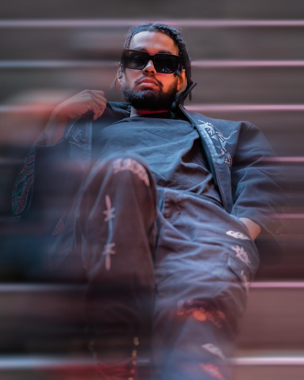 Editorial portrait of a man in sunglasses seated on city stairs