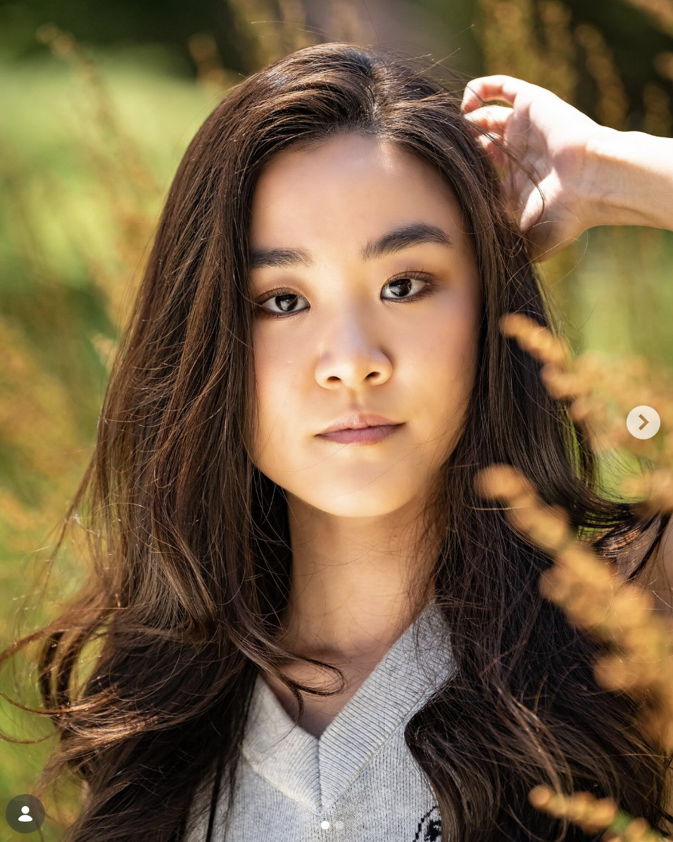 Portrait of a young woman in golden afternoon light among tall grasses