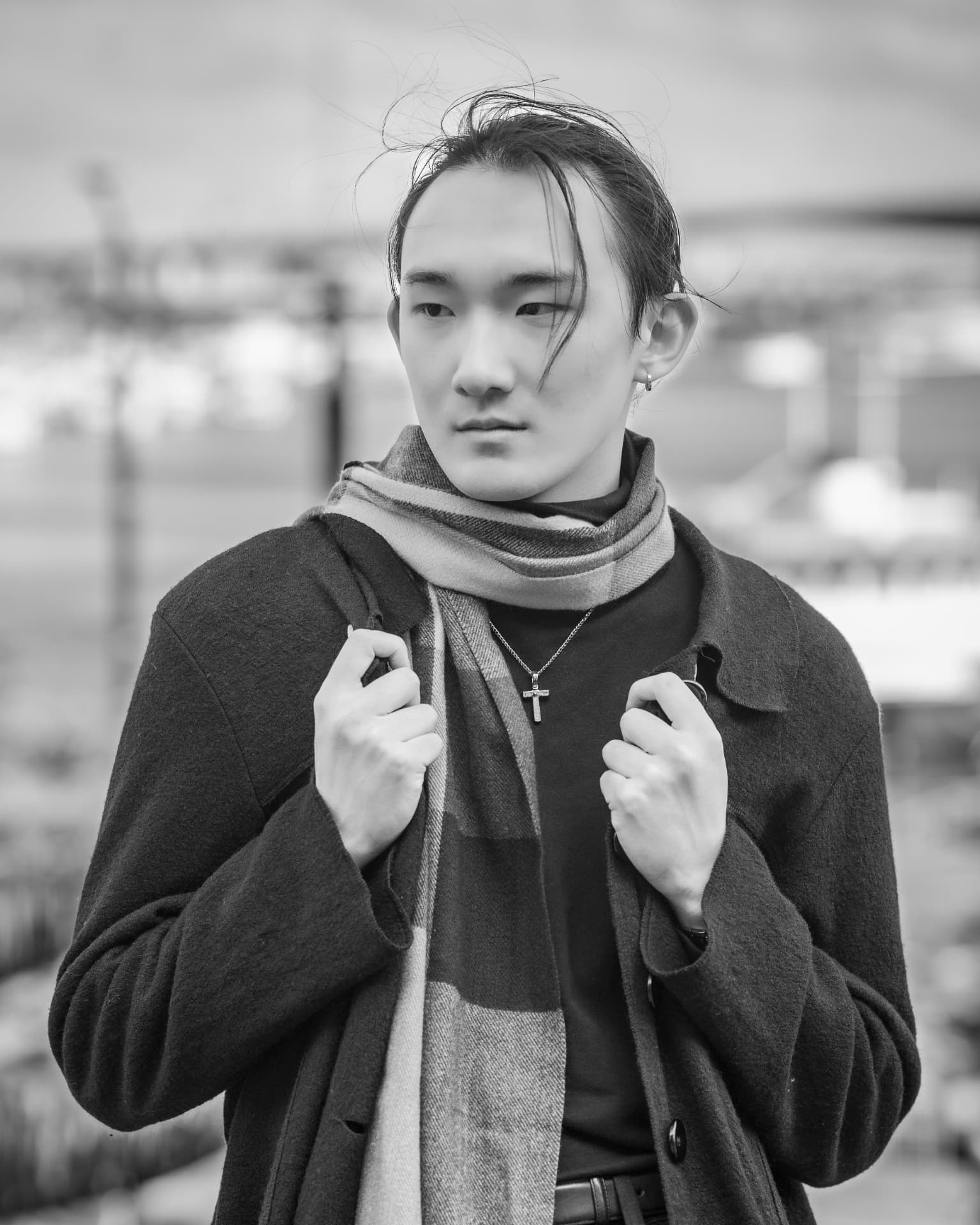 Black and white portrait of a man in a scarf and coat