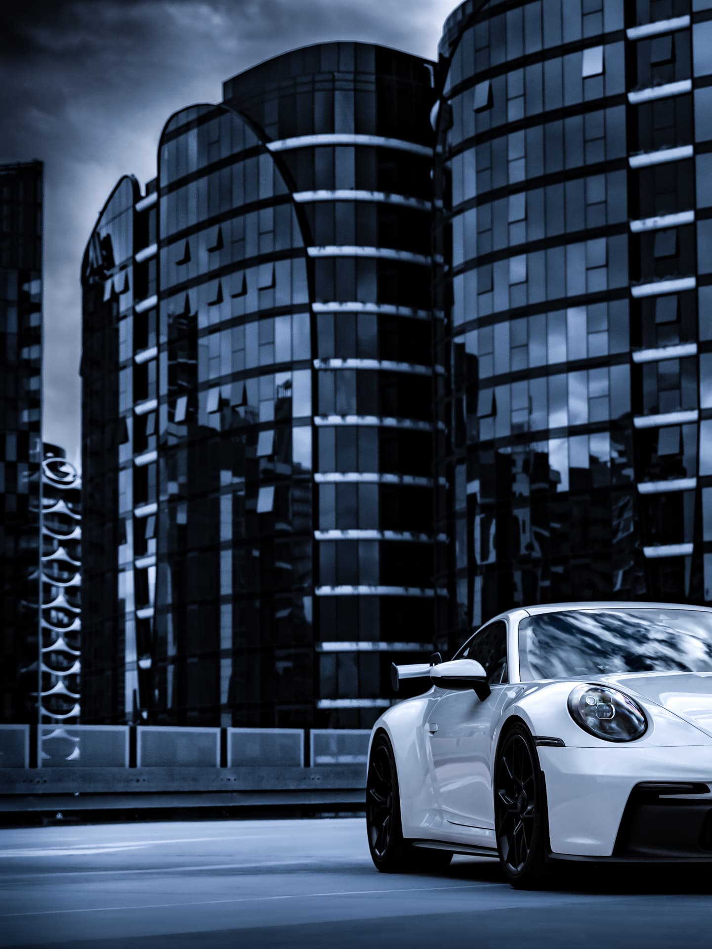 White Porsche 911 GT3 front detail with glass buildings behind