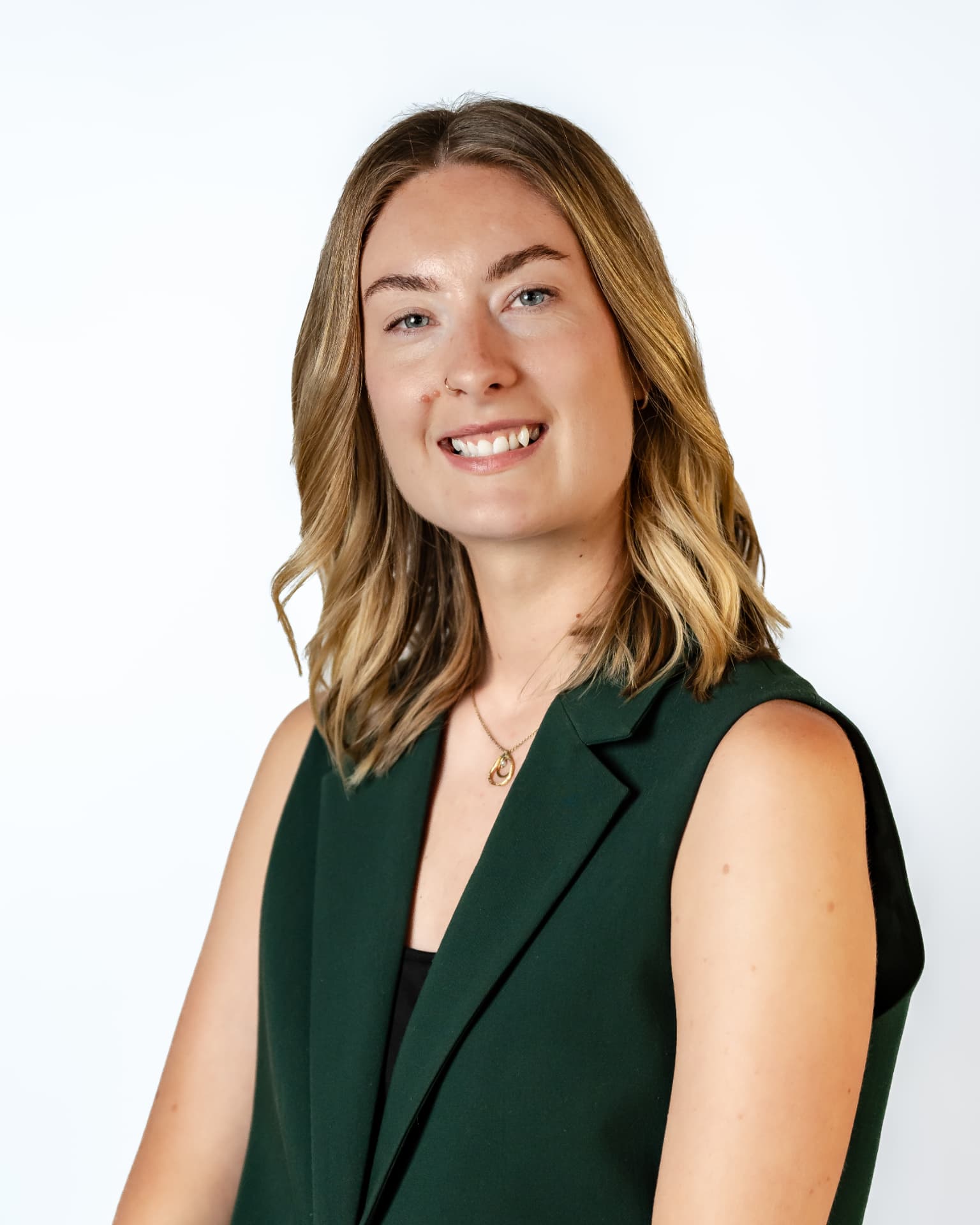Professional headshot of a woman in a green vest