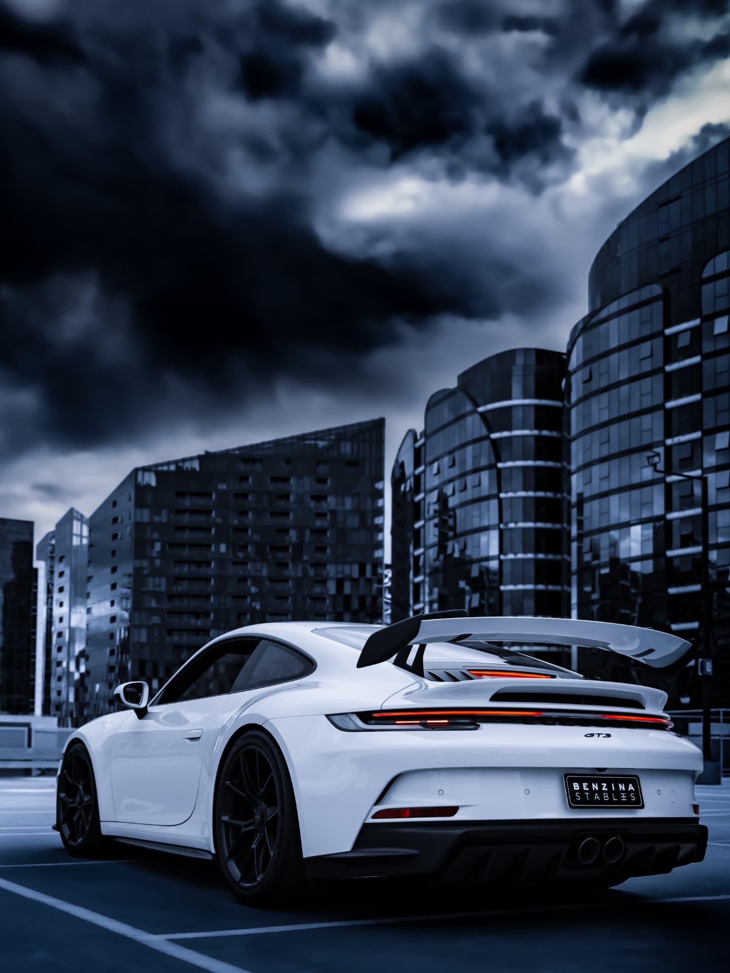 White Porsche 911 GT3 rear view against city towers